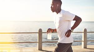 Healthy, active man running by water